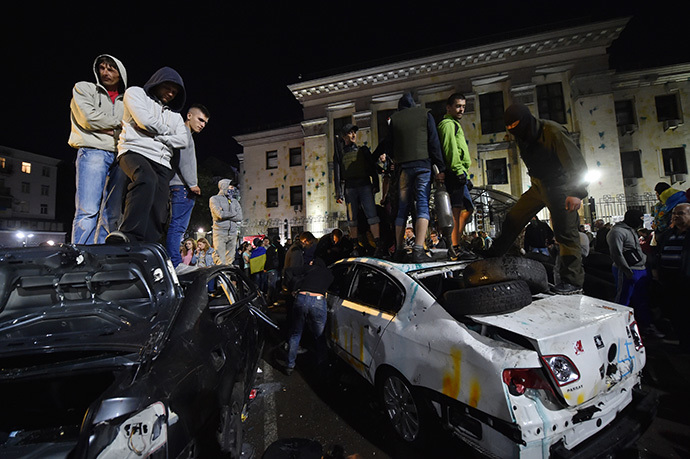 Vandals stand on top of the crashed cars during an attack on the Russian embassy in Kiev on June 14, 2014. (AFP Photo / Sergei Supinsky)