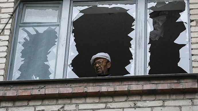 A man looks out of the broken window of his home in a residential building which was damaged by what locals say was overnight shelling by Ukrainian forces, in the eastern Ukrainian town of Slaviansk June 12, 2014. (Reuters / Gleb Garanich)