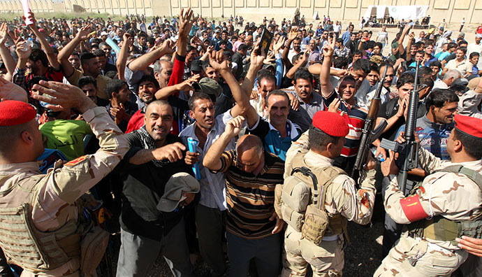 Iraqi men, who volunteered to fight against the Jihadist militants, gather around buses in Baghdad on June 13, 2014, as security forces are bolstering defenses in the capital. (AFP Photo / Sabah Arar)