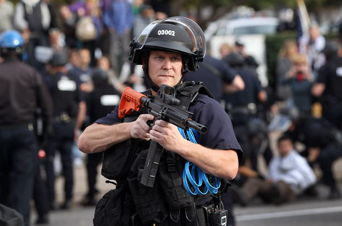 A policeman in riot gear points his weapon at demonstrators as police arrest a protester at the "Occupy Denver" camp on October 29, 2011 in Denver, Colorado. (AFP Photo / Getty Images / John Moore)