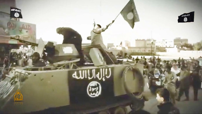 Militants from the Islamic State of Iraq and the Levant (ISIL) parading over an armoured personell carrier at an undisclosed location. (AFP Photo / HO / Youtube)