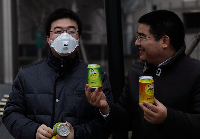 ARCHIVE PHOTO: Chinese multimillionaire Chen Guangbiao (R) gives a can of fresh air to a man wearing a mask on a hazy day in central Beijing, January 30, 2013 (Reuters / Barry Huang)