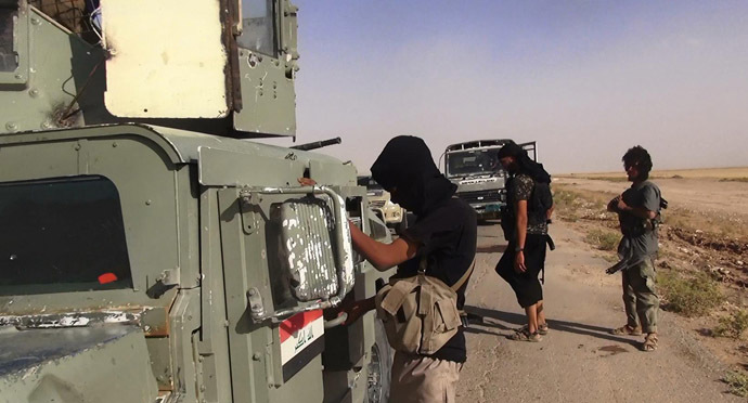 An image made available by the jihadist Twitter account Al-Baraka news on June 13, 2014 allegedly shows Islamic State of Iraq and the Levant (ISIL) militants inspecting abandoned Iraqi army vehicles at an undisclosed location close to the Iraqi-Syrian border, in the district of Sinjar, northwest Iraq. (AFP Photo)
