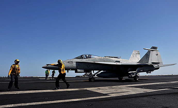 In this image released by the US Navy, sailors direct an F/A-18C Hornet on the flight deck of the aircraft carrier USS George H.W. Bush during flight operations in the Arabian Gulf on June 17, 2014. (AFP Photo / Maggie Keith)