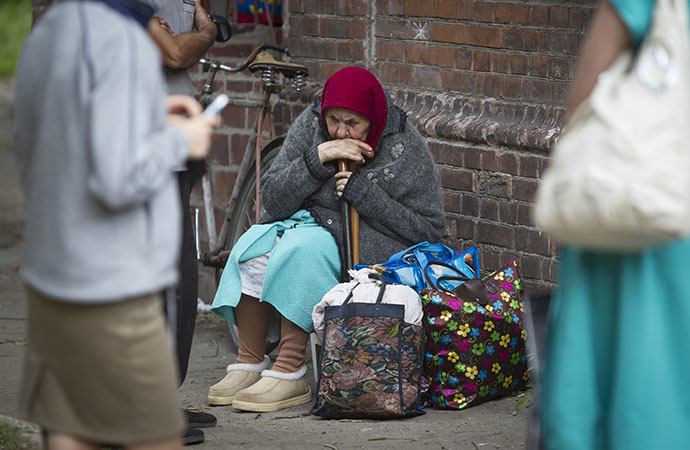 A woman sits on the ground while waiting for a bus to leave the eastern Ukranian city of Slaviansk June 17, 2014. (Reuters / Shamil Zhumatov)