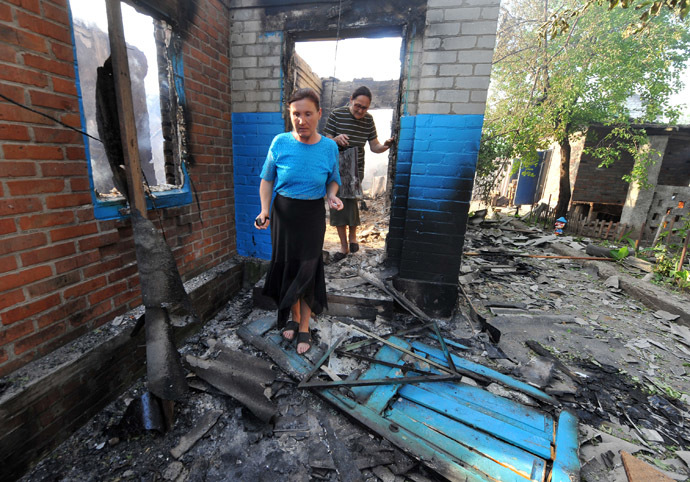 Local residents walk near a house destroyed during a night combat between Ukrainian and anti-government forces in the village of Semenovka, near the eastern Ukrainian city of Slavyansk, on May 23, 2014. (AFP Photo)