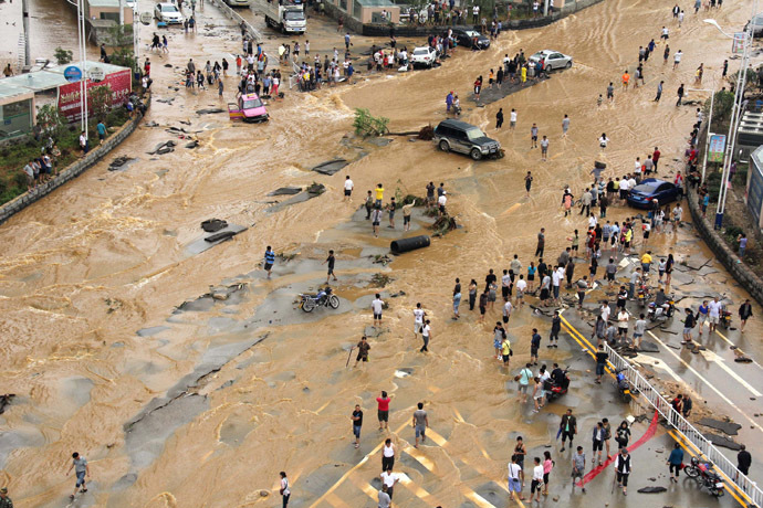 Residents make their way through a heavily-flooded street in Anshun city in Pingba county, southwest China's Guizhou province on June 3, 2014. (AFP Photo)