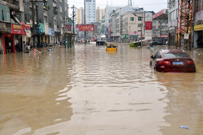 his picture taken on June 4, 2014 shows cars parked on a heavily flooded street in Shiqian county of Tongren, southwest China's Guizhou province. (AFP Photo)