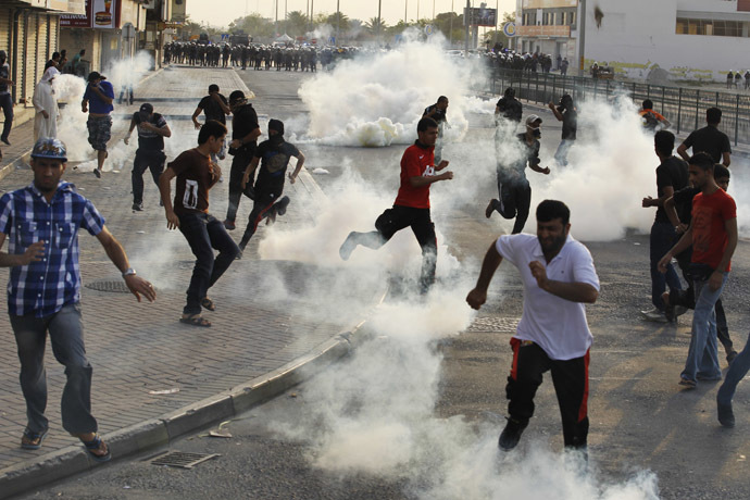 Anti-government protesters take cover from tear-gas fired by the police as they clash during a funeral procession for fellow protester Sayed Mohsen, in the village of Sitra south of Manama, May 27, 2014. (Reuters/Hamad I Mohammed)