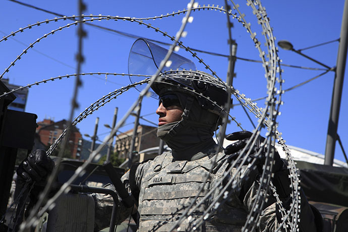 A U.S. soldier, part of a NATO peace force, places barbed wire on his Humvee during a protest in the ethnically divided town of Mitrovica June 22, 2014. (Reuters / Hazir Reka)