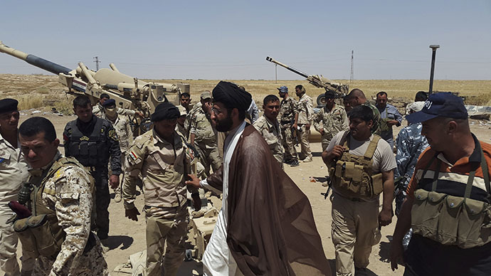 A Shiite cleric visits members of Iraqi security forces and volunteers, who have joined the Iraqi security forces to fight against the predominantly Sunni militants from the radical Islamic State of Iraq and the Levant (ISIL) who have taken over Mosul and other northern provinces, on the outskirts of Diyala province June 16, 2014. (Reuters)