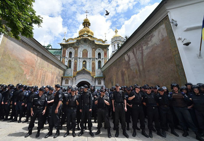 Ukrainian policemen guard the entrance of Kiev Pechersk Lavra, an Orthodox Christian complex of monasteries and cathedrals in Kiev, to prevent storming by activists of various pro-Ukrainian radical youth groups on June 22, 2014. (AFP Photo / Sergei Supinsky)