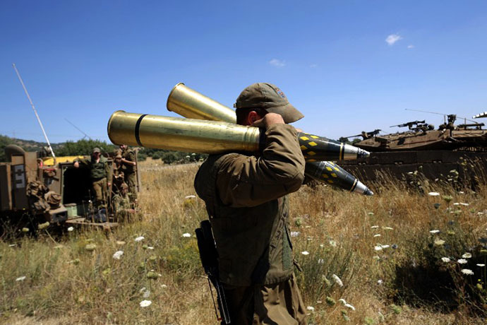 An Israeli soldier prepares to load shells into his Merkava tank positioned near the Quneitra checkpoint on the border with Syria in the Israeli-annexed Golan Heights, on June 22, 2014. (AFP Photo / Menahem Kahana)