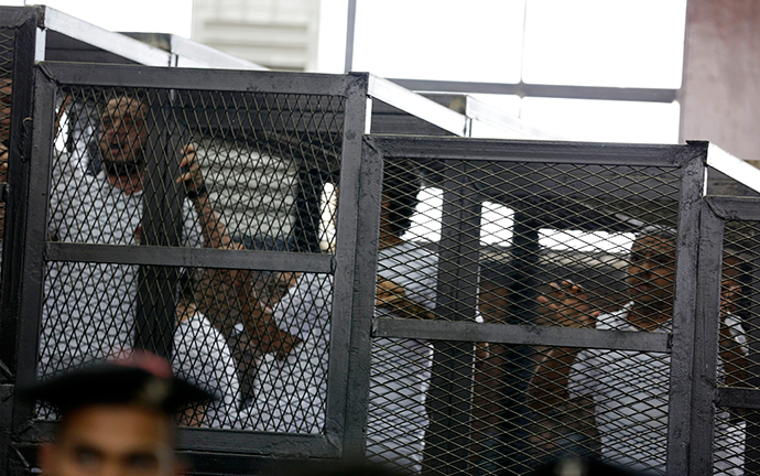 Mohamed Fahmy (R) and other defendants react after hearing the ruling at a court in Cairo June 23, 2014 (Reuters / Asmaa Waguih)