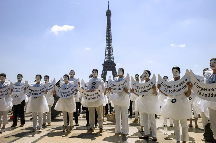 People dressed as the traditionnal theatre character "Pierrot" hold placards reading "Urgency is to solidarity" as they take part in a demonstration against euthanasia for elderly and dependent people on June 24, 2014 on the Trocadero esplanade, also called the Parvis of Human Rights, near the Eiffel Tower in Paris. (AFP Photo/Fred Dufour)