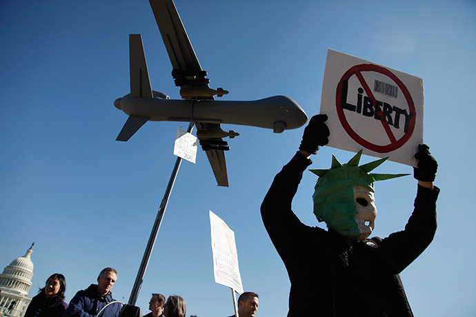 A protester wears a mask depicting a skull beneath the head of the Statue of Liberty, as he demonstrates beneath a model of a U.S. drone aircraft near the U.S. Capitol in Washington (Reuters / Jonathan Ernst)