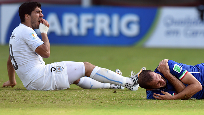 Uruguay's forward Luis Suarez (L) reacts past Italy's defender Giorgio Chiellini during a Group D football match between Italy and Uruguay at the Dunas Arena in Natal during the 2014 FIFA World Cup on June 24, 2014. (AFP Photo / Javier Soriano)