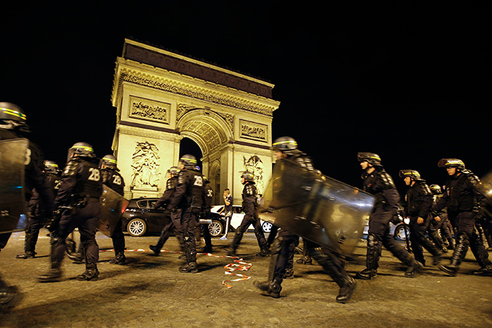 French CRS riot police officers secure the Arc de Triomphe as Algerian fans celebrate after Algeria's 2014 World Cup Group H soccer match against Russia, in Paris early June 27, 2014 (Reuters / Gonzalo Fuentes)