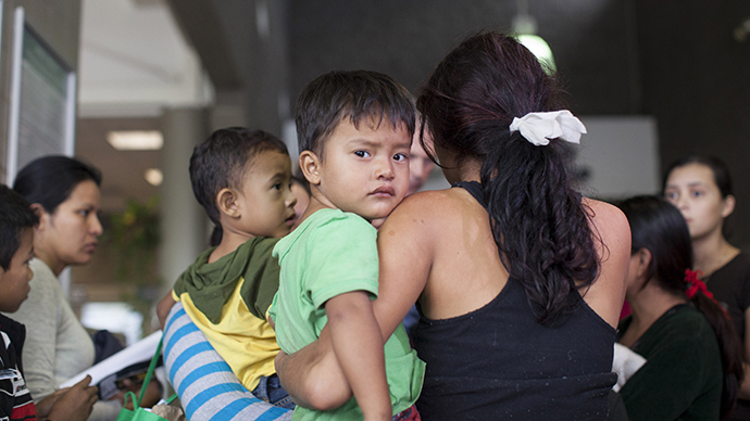 Migrants, consisting of mostly women and children, who just disembarked from a U.S. Immigration and Customs Enforcement (ICE) bus wait for a Greyhound official to process their tickets to their next destination at a Greyhound bus station in Phoenix, Arizona May 29, 2014. (Reuters / Samantha Sais)