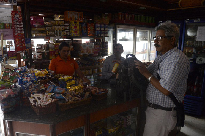 People shop at a minimarket during a power cut in Caracas, on June 27, 2014. (AFP Photo / Leo Ramirez)