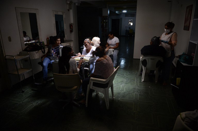 A hairdressing salon in the dark during a power cut in Caracas, on June 27, 2014. (AFP Photo / Leo Ramirez)