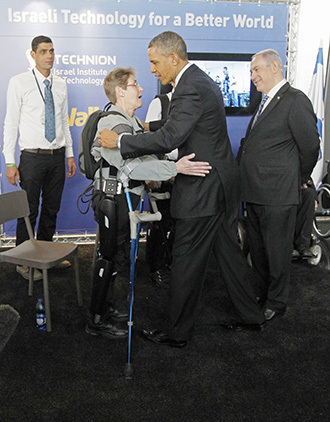 U.S. President Obama hugs U.S. Army Sergeant Hannigan as she wears an electronic leg technology named ReWalk during a tour of the technology expo in Jerusalem. (Reuters / Jason Reed)
