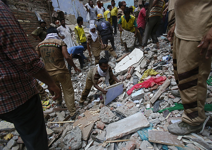 Rescue workers clear the debris from the site of a collapsed building in New Delhi June 28, 2014. (Reuters / Anindito Mukherjee)
