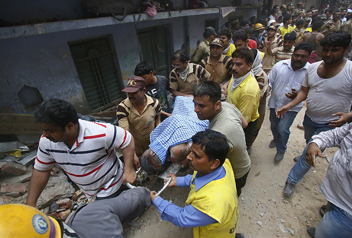 An injured man is taken to an ambulance from the site of a collapsed building in New Delhi June 28, 2014. (Reuters / Anindito Mukherjee)