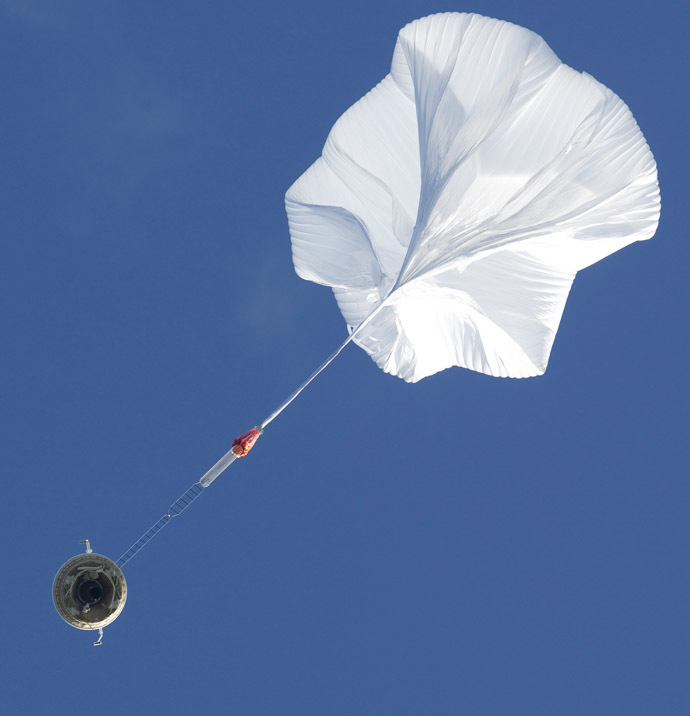 A high altitude balloon lifts a saucer-shaped test vehicle, which holds equipment for landing large payloads on Mars, at the U.S. Navy's Pacific Missile Range Facility in Kauai, Hawaii June 28, 2014. (Reuters/Marco Garcia)