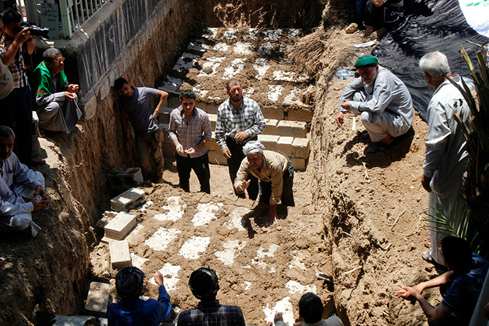 Mourners bury the bodies of victims, who were killed in Tuz Khurmato, during a funeral in Kirkuk, June 23, 2014 (Reuters / Ako Rasheed)