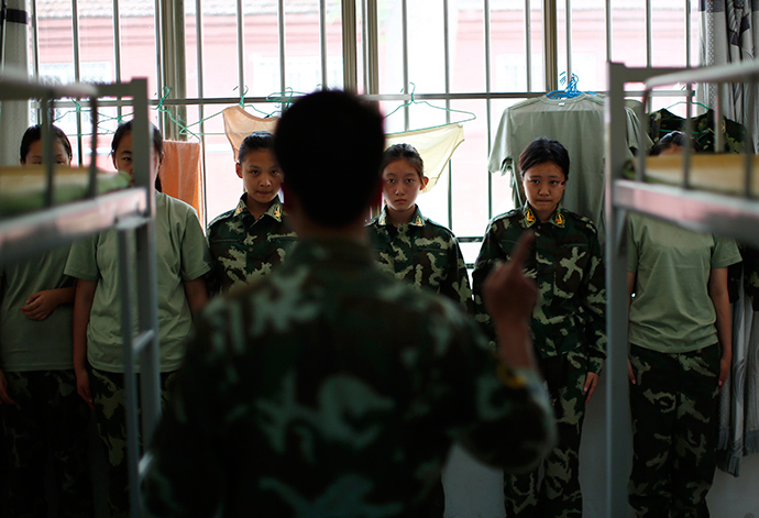 An instructor who is an ex-soldier talks to female students in their dormitory at the Qide Education Center in Beijing June 10, 2014 (Reuters / Kim Kyung-Hoon)