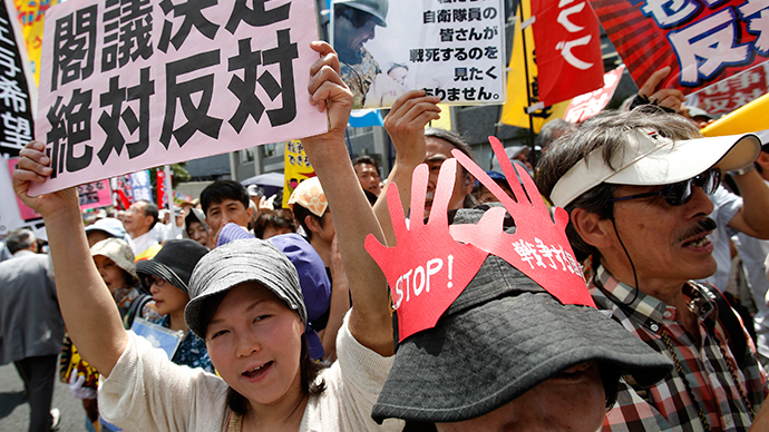 Protesters holding placards shout slogans at a rally against Japan's Prime Minister Shinzo Abe's push to expand Japan's military role in front of Abe's official residence in Tokyo July 1, 2014 (Reuters / Yuya Shino)