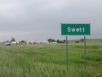 The town limit sign, with Swett in the background. Photo from zillow.com