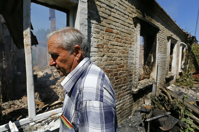 Local resident Viktor Shevchenko walks outside a building damaged by a recent shelling in the Ukrainian eastern city of Slaviansk July 1, 2014. (Reuters/Shamil Zhumatov)