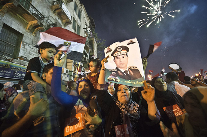 People celebrate at Tahrir Square with a portrait of Army chief Abdel Fattah al-Sisi after a broadcast confirming that the army will temporarily be taking over from the country's first democratically elected president Mohamed Morsi on July 3, 2013 in Cairo. (AFP Photo / Khaled Desouki)