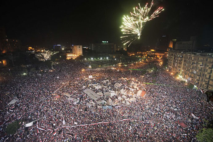 Fireworks light up the sky as Hundreds of thousands of Egyptians celebrate after Egytptian Defense Minister Adel Fattah al-Sisi's speech announcing The Egyptian army toppling Islamist President Mohamed Morsi in Egypt's landmark Tahrir square on July 3, 2013 in Cairo, Egypt. (AFP Photo / Gianluigi Guercia)