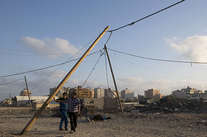 Palestinian men inspect damages following an overnight Israeli air strike, on July 3, 2014 in Gaza City. (AFP Photo / Mohammed Abed)