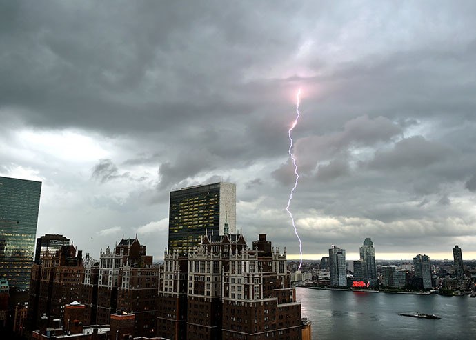 With the United Nations and Tudor City in the foreground, lightning strikes in the sky over the East River as a major storm approaches New York City July 2, 2014. (AFP Photo / Timothy A. Clary)