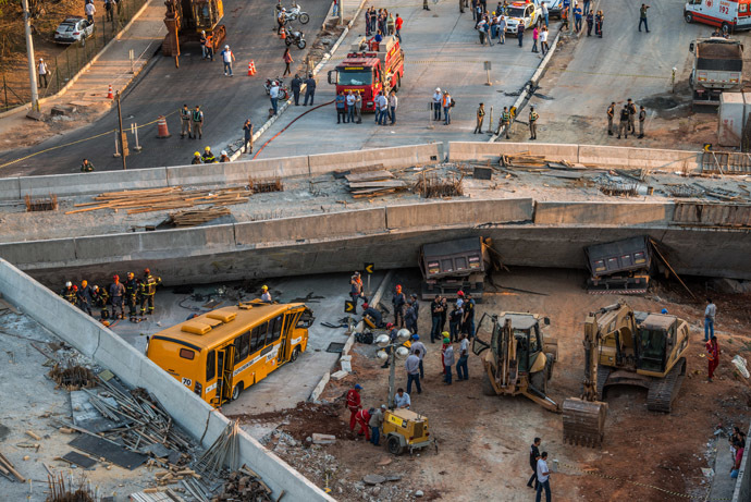 Firefighters and policemen work at the site where a bus and trucks were crushed by a viaduct that collapsed in Belo Horizonte, Brazil, on July 3, 2014 (AFP Photo/Pedro Duarte)