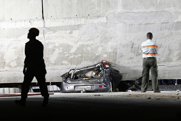 A car is trapped underneath a bridge that collapsed while under construction in Belo Horizonte July 3, 2014. (Reuters/Ivan Alvarado)