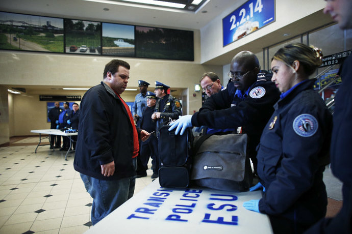 Members of the Transportation Security Administration (TSA) check a passenger's bags with N.J. Transit Police to secure mass transit for the Super Bowl XLVIII, in Secaucus, New Jersey January 31, 2014. (Reuters/Eduardo Munoz)