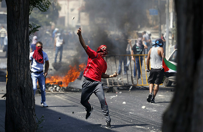 A Palestinian throws a stone during clashes with Israeli police after prayers on the first Friday of the holy month of Ramadan in the East Jerusalem neighbourhood of Wadi al-Joz July 4, 2014. (Reuters / Baz Ratner)