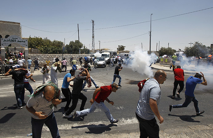 Palestinian protesters run away from tear gas fired by Israeli soldiers during clashes after Friday prayers in the Arab east Jerusalem neighbourhood of Ras al-Amud July 4, 2014. (Reuters / Ammar Awad)