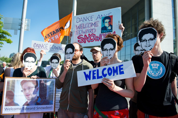 Activists of German Pirate party wearing mask featuring US intelligence leaker Edward Snowden attend a rally on May 22, 2014 in front of Bundestag, German parliament, in Berlin. (AFP Photo/DPA)