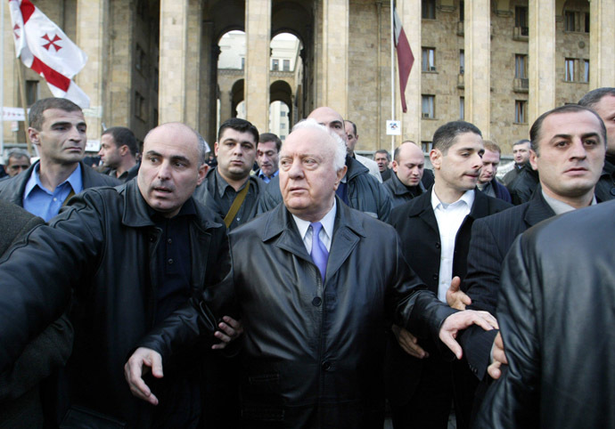 Georgian President Eduard Shevarnadze walks surrounded by bodyguards outside Parliament building in Tbilisi, 09 November 2003. (AFP Photo/Victor Drachev)