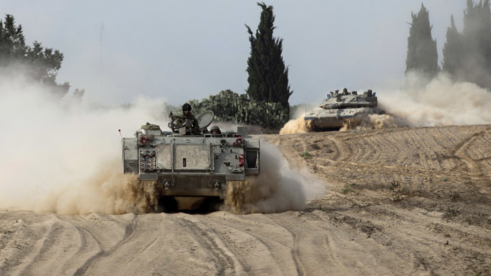 Israeli soldiers ride atop an armoured personnel carrier (APC) near a tank (R) outside the southern Gaza Strip July 7, 2014. Israeli air strikes killed seven Hamas militants in the Gaza Strip on Monday, the Islamist group said, in the deadliest attacks in a surge of violence exacerbated by the kidnapping and killing of three Israeli youths and a Palestinian teen. (Reuters)