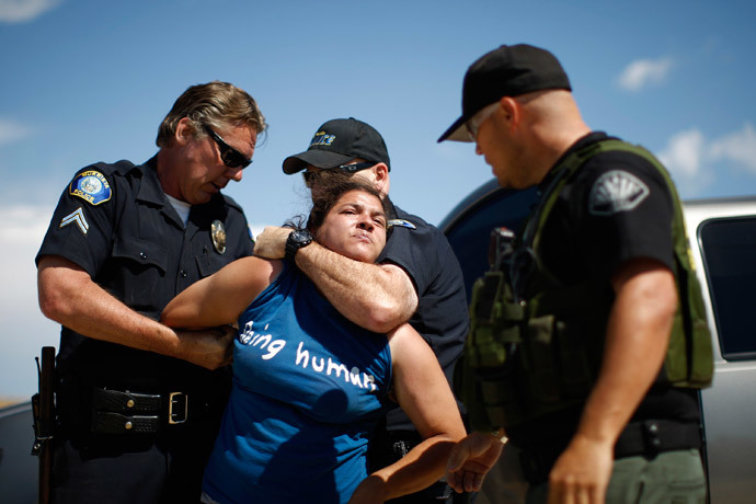 A counter-demonstrator to protesters opposing arrivals of buses carrying largely women and children undocumented migrants for processing at the Murrieta Border Patrol Station is arrested on July 4, 2014 in Murrieta, California.(AFP Photo / David McNew)