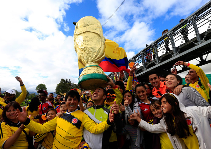 Colombian fans pose with a big replica of the World Cup 2014 trophy as they wait for the arrival of Colombia's national soccer team in Bogota July 6, 2014.(Reuters / Jose Miguel Gomez)