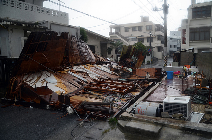 A wooden house collapsed during strong winds in Naha on Japan's southern island of Okinawa on July 8, 2014 (AFP Photo / Jiji Press)