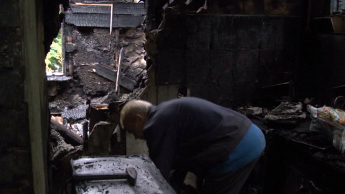 A local resident in destroyed house in Lugansk (screenshot from RT)